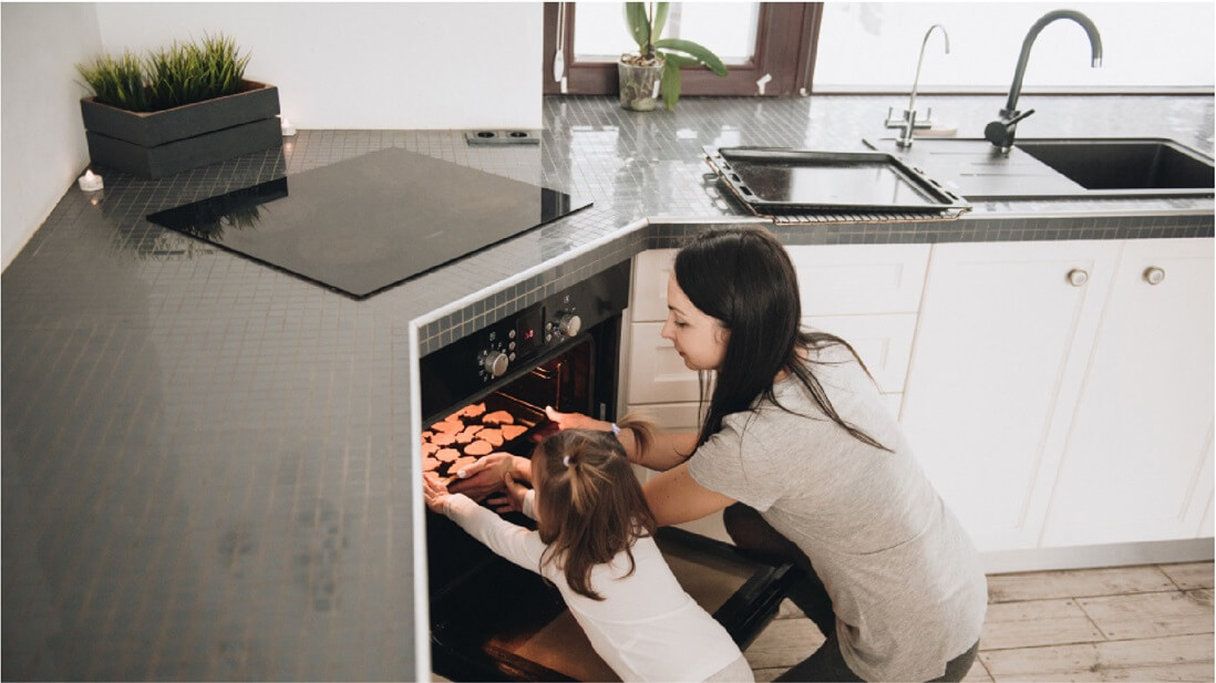 mother and chlid using hidden oven in kitchen